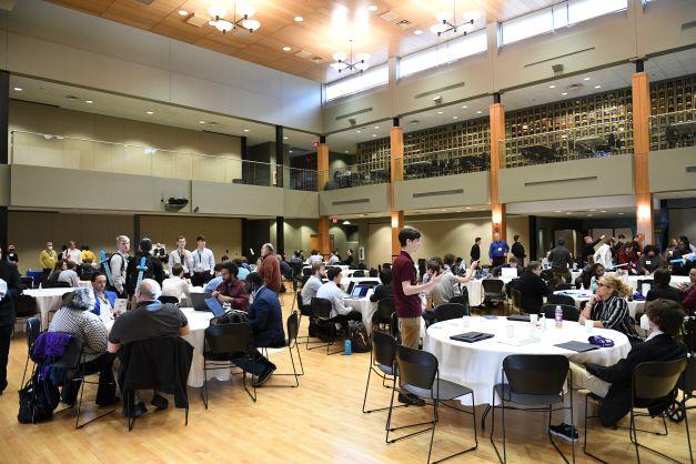College students and professors discussing the competition over a buffet lunch